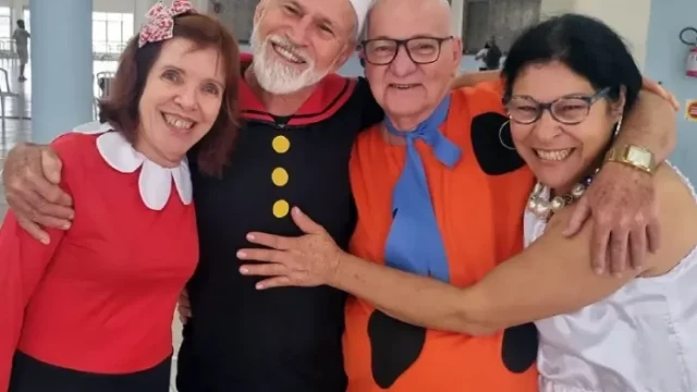 Idosos se divertindo em bailinho de carnaval com decoração temática