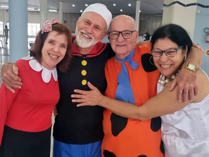 Idosos se divertindo em bailinho de carnaval com decoração temática