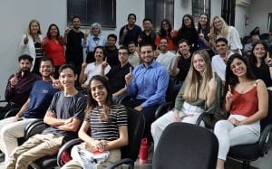 Estudantes fazendo gesto com as mãos durante aula inaugural