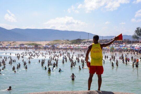 Guarda-vidas do CBMSC resgatando banhista na praia