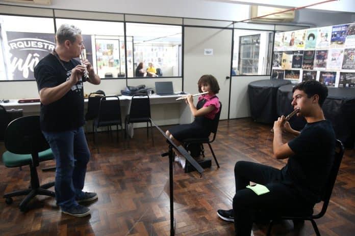 Alunos tocando violino na escola de música