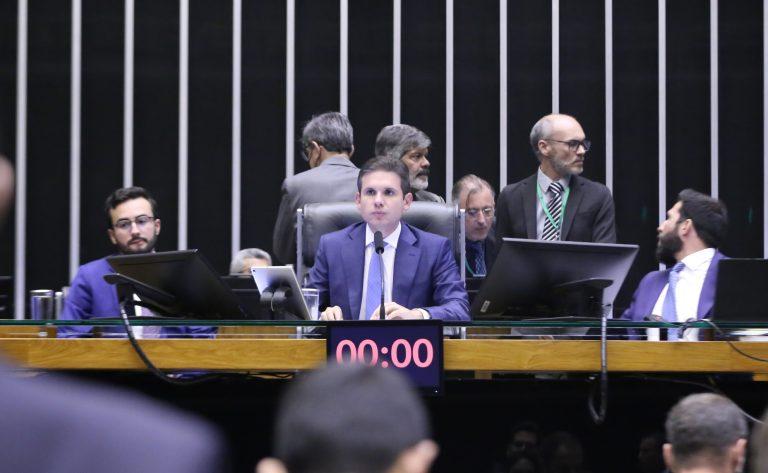 Deputados na Câmara dos Deputados analisando pedidos de urgência para projetos de lei