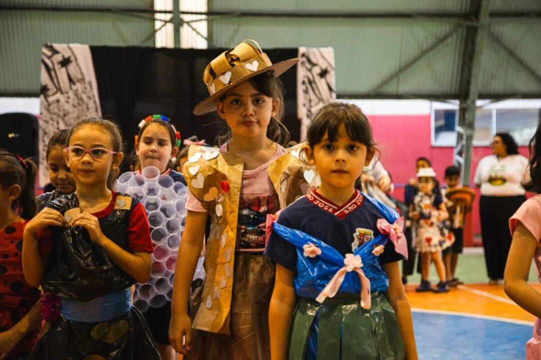 Alunos desfilando roupas feitas com materiais recicláveis