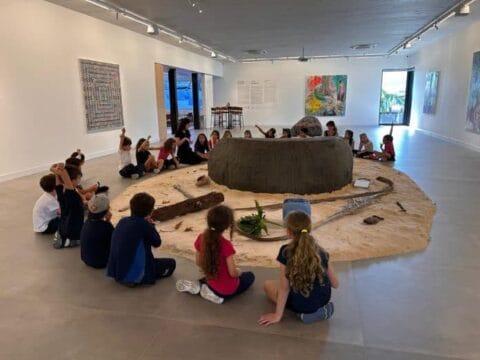 Exposição de arte com visitantes interagindo