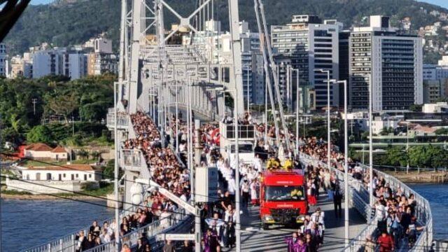 Multidão celebrando procissão na Ponte Hercílio Luz em honra a Nossa Senhora de Fátima