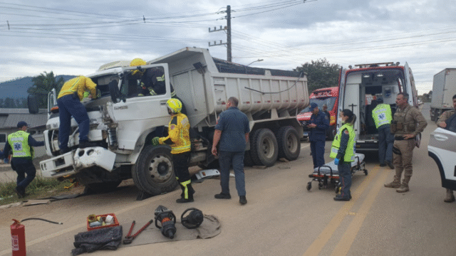 Equipe de resgate do Corpo de Bombeiros Militar atendendo vítima de acidente entre caminhões
