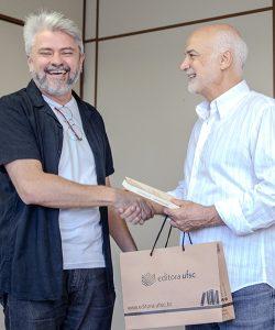 Salvador Gomes segurando o livro 'Labirintos do Poder' entregue por Nildo Ouriques