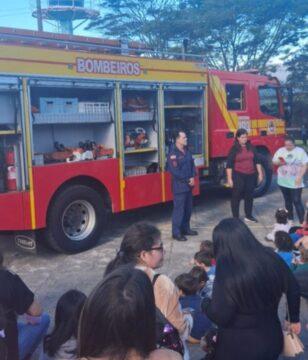 Crianças interagem com bombeiros durante atividade educativa