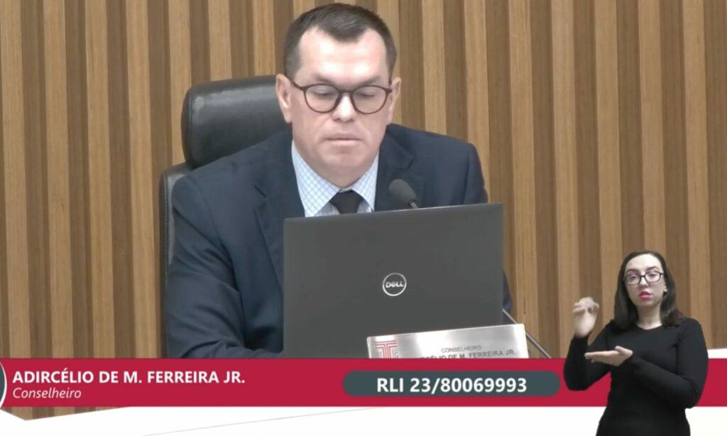 Conselheiro do Tribunal de Contas do Estado lendo o relatório sobre a retenção ilegal de verbas estaduais