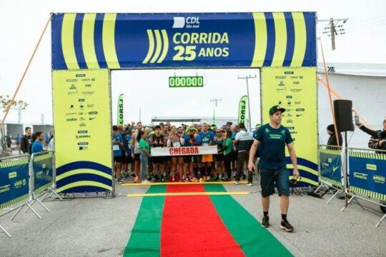 Corredores participando da Corrida CDL-SJ 2025 com os marcos históricos de São José ao fundo