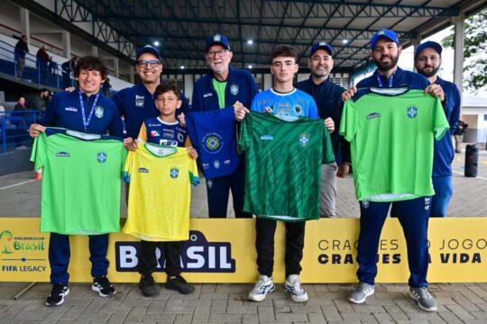 Crianças recebendo uniformes e materiais esportivos do Projeto Gol do Brasil