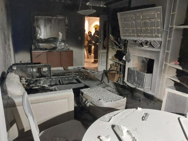 Bombeiros resgatando morador e cachorro em apartamento em chamas