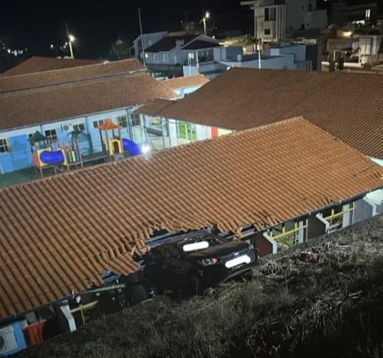 Bombeiros resgatando vítima de carro preso em telhado