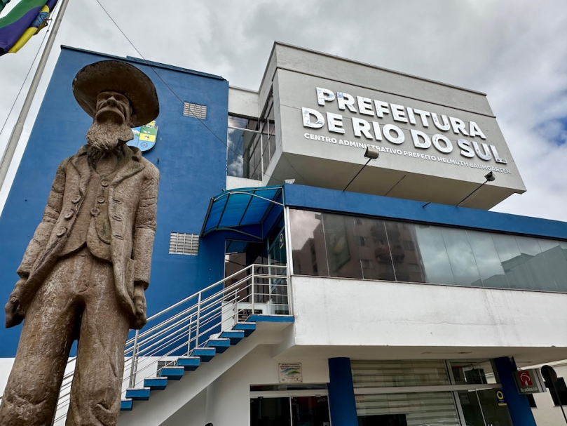 Imagem ilustrativa de pessoas preenchendo formulários em mesa de concurso público