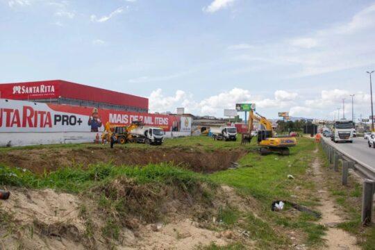 Trabalhadores realizando limpeza e desassoreamento nas margens da Via Expressa em São José