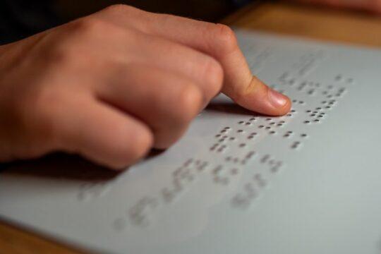 Pessoa lendo etiqueta em Braille