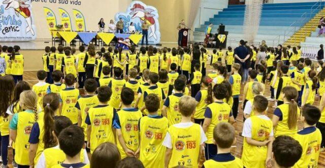 Crianças recebendo certificados na formatura do Programa Golfinho