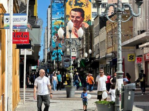 Fachada de lojas com letreiro destacando a abertura no feriado