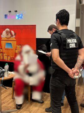 Homem vestido de Papai Noel sendo preso
