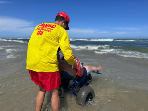 Homem desfrutando do mar com segurança na cadeira anfíbia