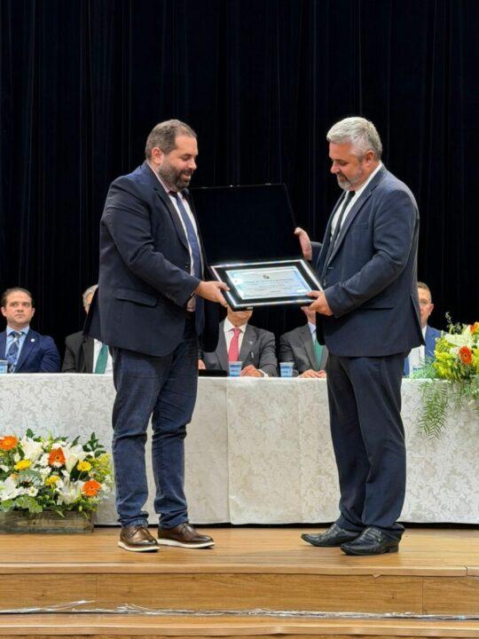 Foto do vereador João Cobalchini recebendo o título de Cidadão Honorário de Palhoça durante sessão solene da Câmara de Palhoça